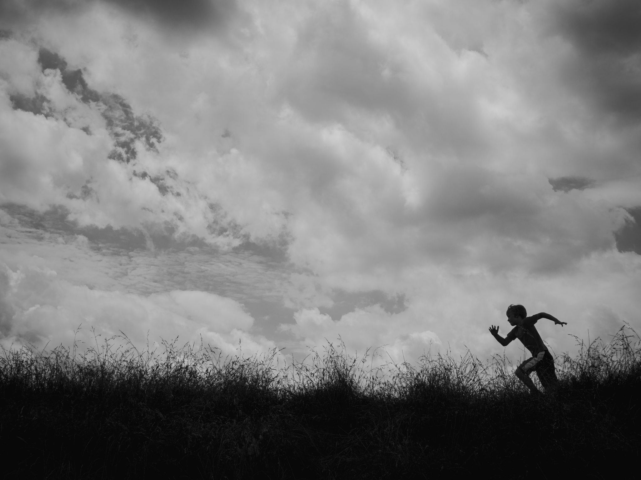 Boy running on a grassy hill